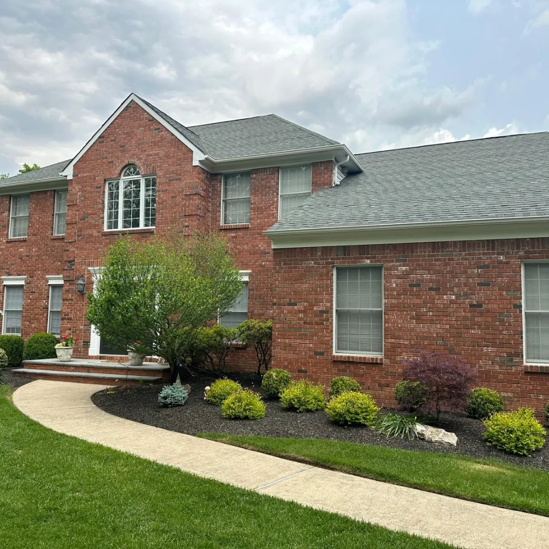 Beautiful brick house with manicured lawn and landscaping.