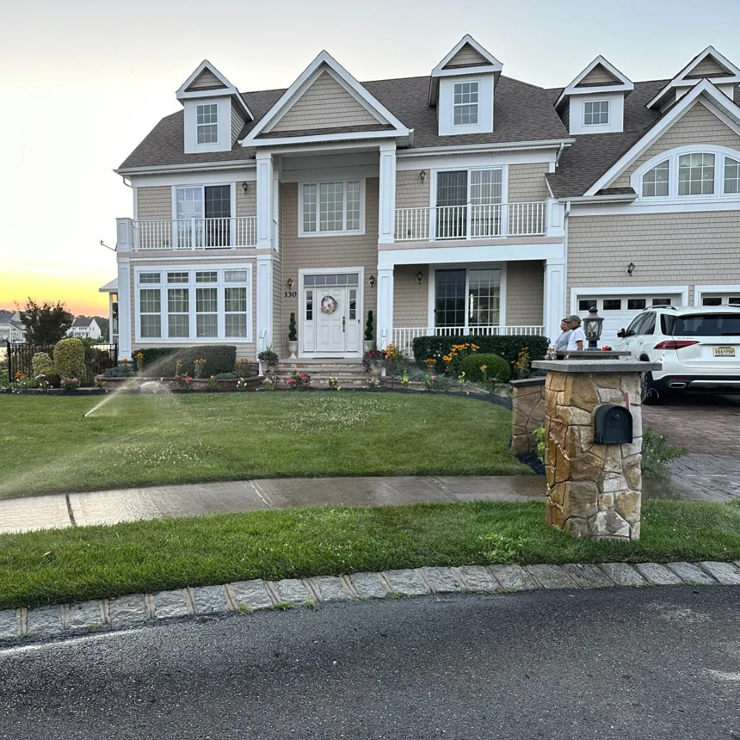 Large house with lush lawn and flowers