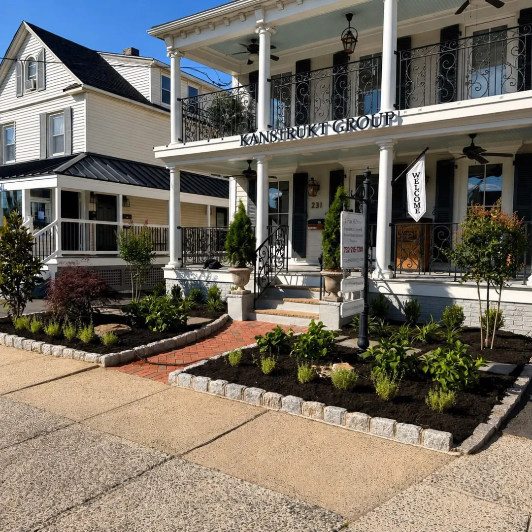 Landscaped front yard with plants and brick pathway.