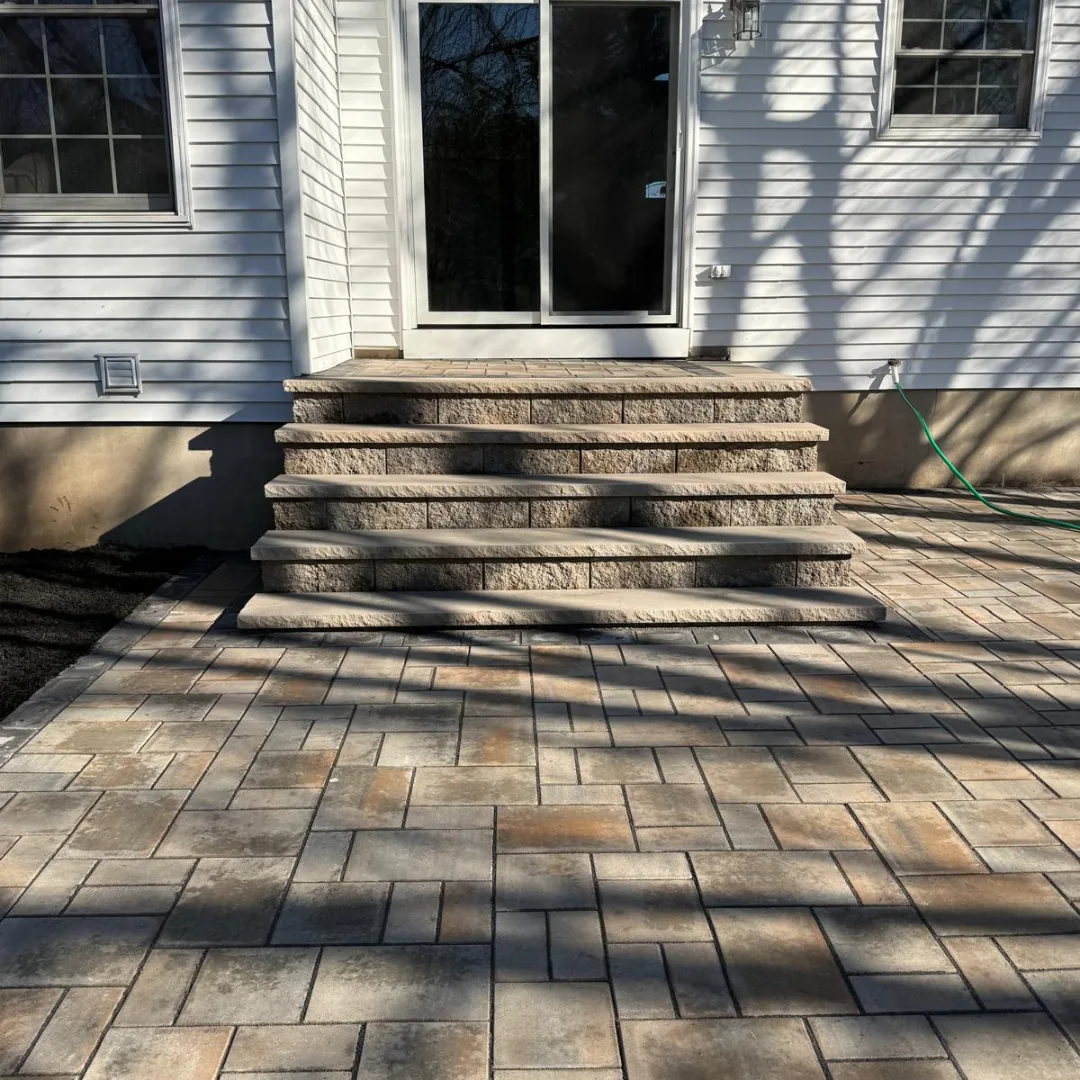 New paver patio and steps leading to house.